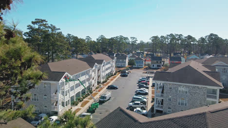 Aerial-flight-over-modern-condos-neighborhood-with-parking-area-during-sunny-day---Myrtle-Beach,South-Carolina
