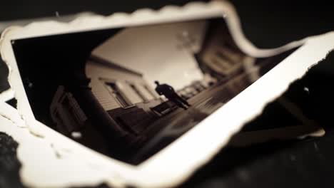 This captures a collection of aged photographs scattered on a table, showcasing a peaceful street in a small town during the late afternoon. The atmosphere evokes nostalgia and reflection.