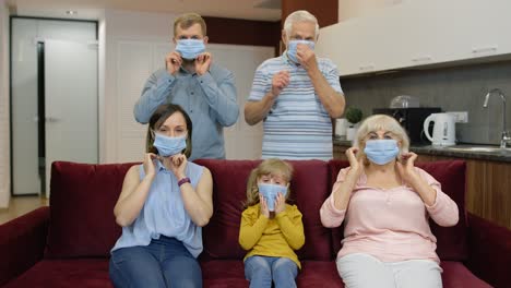 coronavirus quarantine lockdown concept. family puts medical protective masks on faces at home