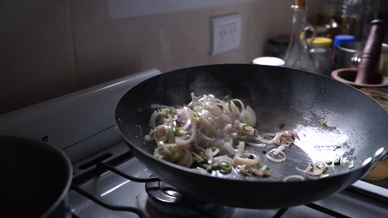 Chef Toss Wok With Chopped Green And White Onions In The Kitchen. - close up