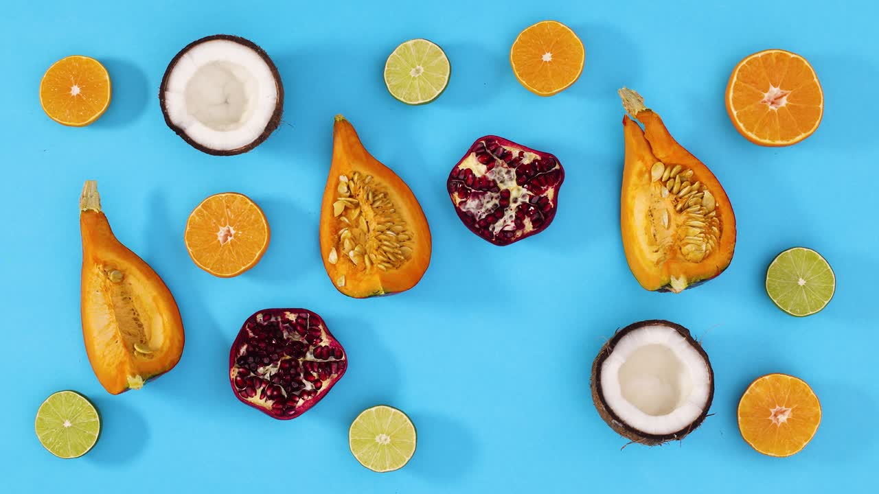 Fette di frutta fresca e tropicale lampeggiano su sfondo blu. Stop motion