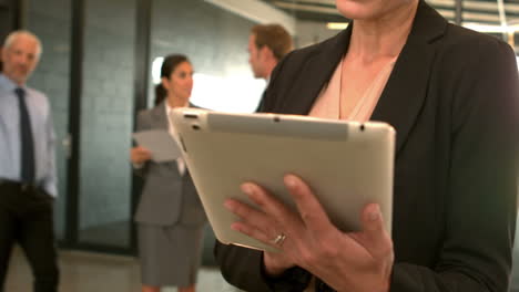 mujer de negocios sonriente usando una tableta digital