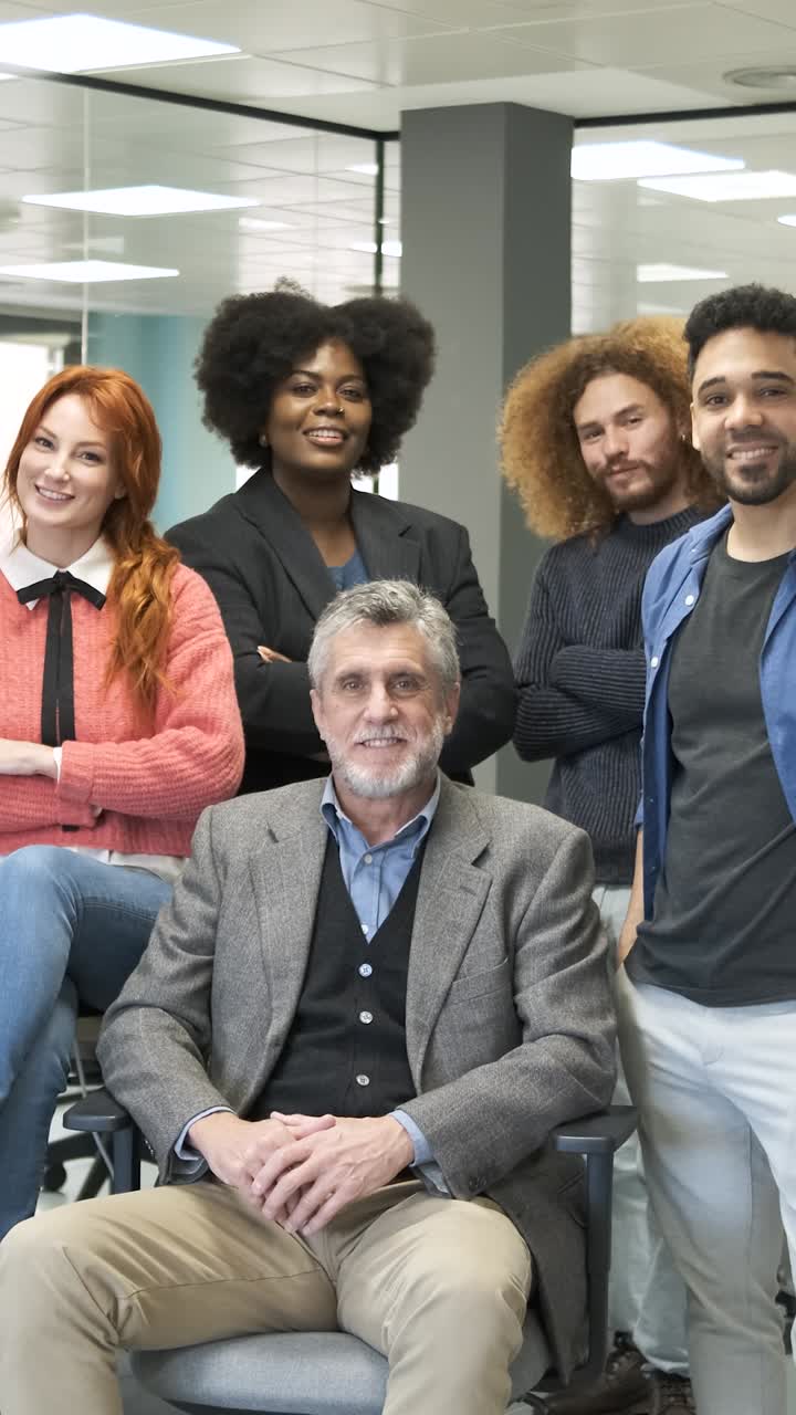 Gruppo di allegri professionisti multietnici in piedi in ufficio