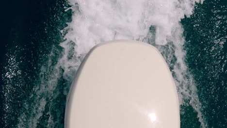 unusual and unique high-angle pov of motorboat engine leaving sea water wake