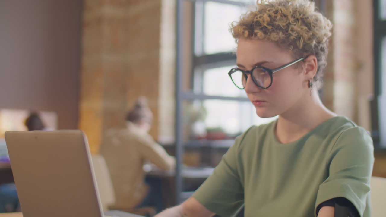 Businesswoman with Prosthetic Arm Working on Laptop in Office