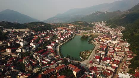 Panorámica-Izquierda-Sobre-La-Ciudad-De-Sapa,-Vietnam,-Con-El-Lago-Sa-Pa-Y-Las-Distantes-Montañas-Nebulosas