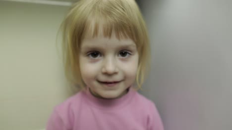 close up of a little blonde cute girl face. girl smiling. inside. portrait shot