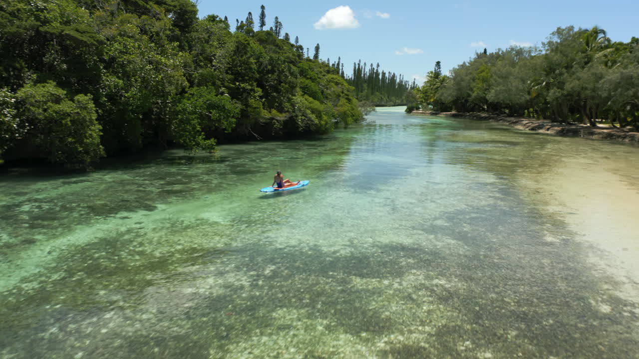 Person paddleboarding in clear tropical waters