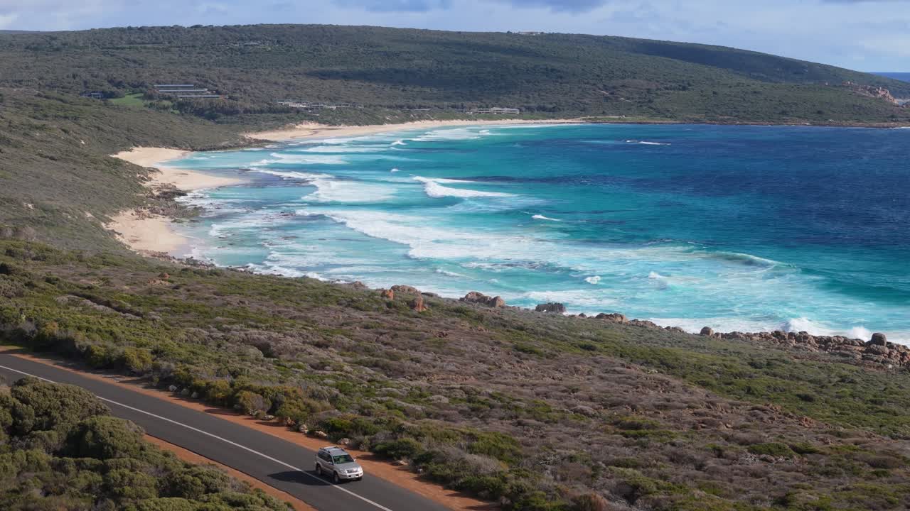 Scenic road in Margaret River with car driving and waves breaking in the background