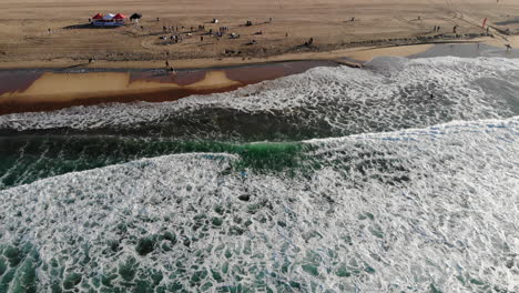 Wide,-static-shot-of-beach-from-waves-at-Huntington-Beach-Pier-surfing-competition-from-aerial-4k-drone-over-Pacific-Ocean,-good-for-background-plate