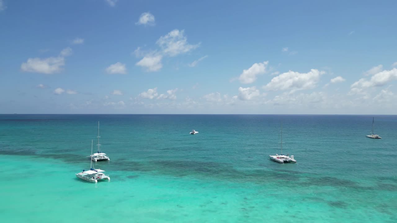 fotografía aérea de una playa llena de turistas y catamaranes en la isla de saona en la república dominicana