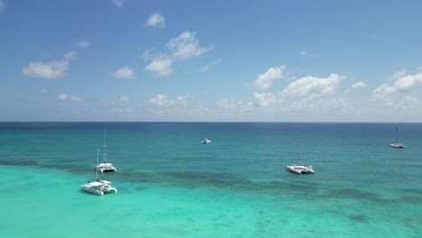 Aerial-establishing-shot-of-a-beach-full-of-tourists-and-catamarans-at-Saona-Island-in-the-Dominican-Republic