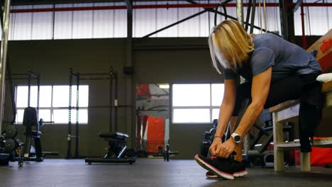 Mujer-Mayor-Atando-Cordones-En-El-Gimnasio-4k