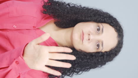 Vertical-video-of-The-young-woman-is-warning-by-looking-at-the-camera.