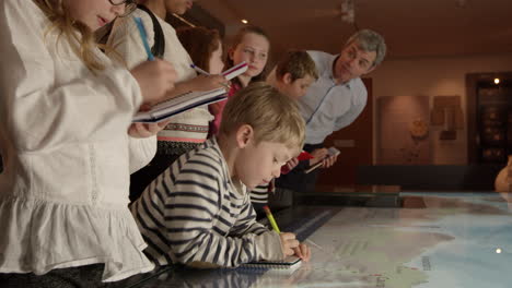 pupils on school trip to museum looking at map shot on r3d