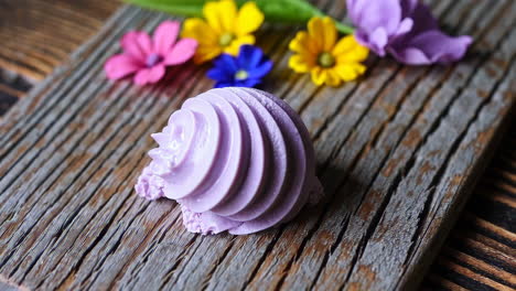 purple swirl meringue on wood with colorful flowers