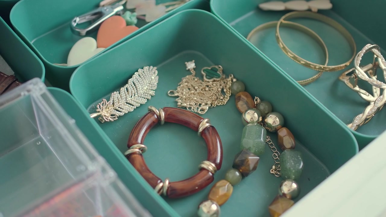Primo piano di vari gioielli e accessori per capelli organizzati in un cassetto