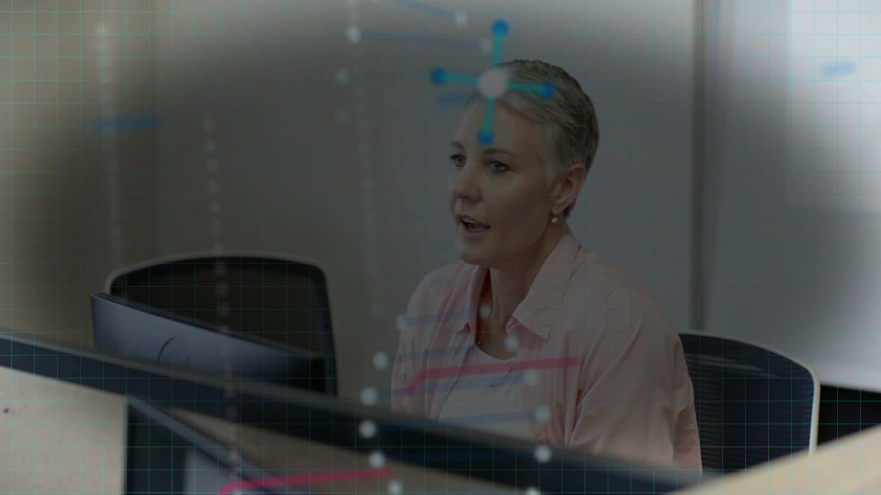 Panoramica della telecamera, donna che si gira e parla di affari, nodi e grafici sul monitor mentre gesticola