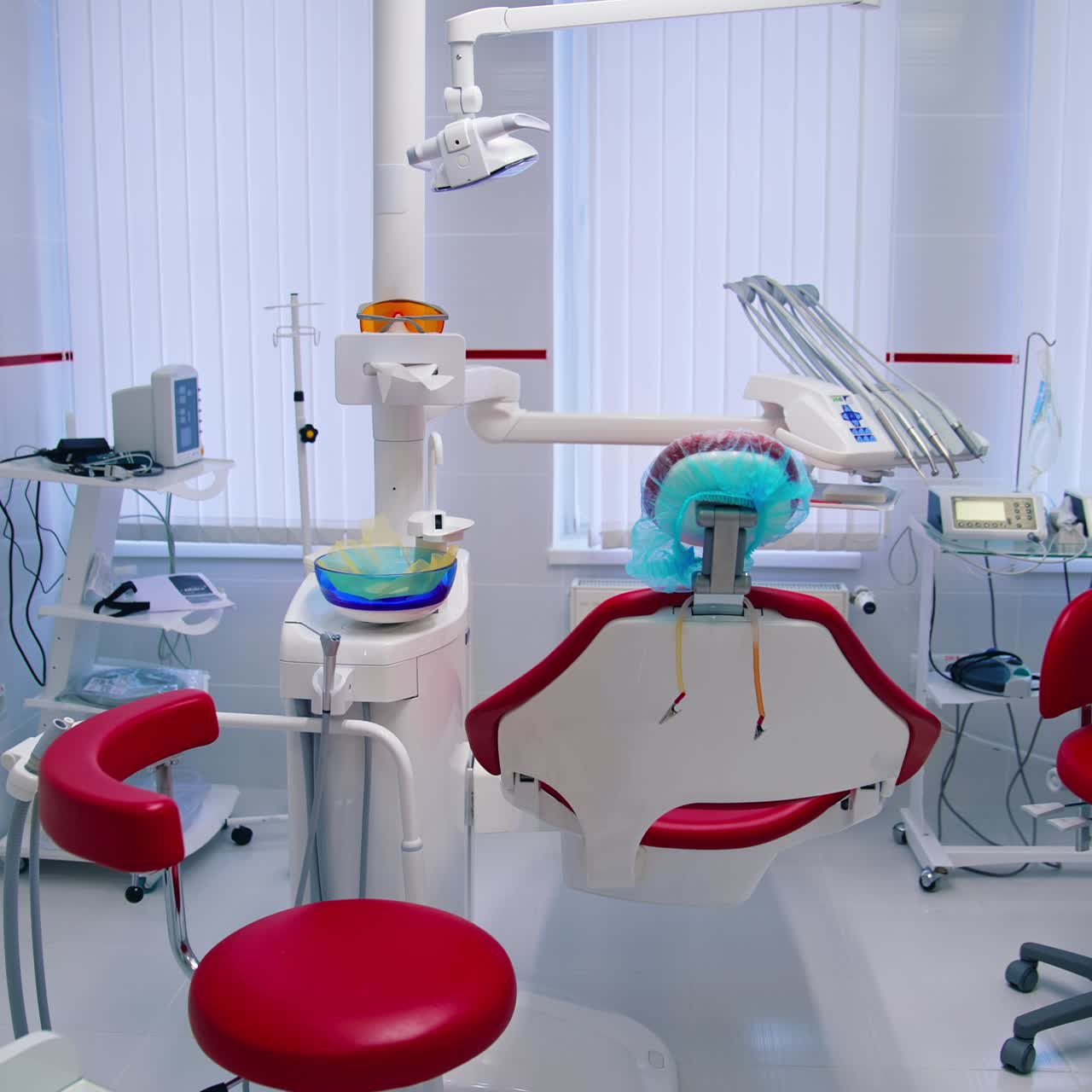 Modern dentist cabinet. Red dental chair and sterile tools in the empty dental office. Teeth care, dental health