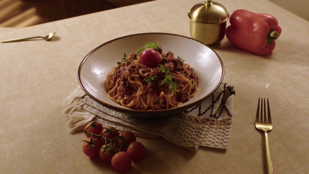 Gustosi spaghetti alla bolognese serviti in una ciotola su un tavolo tradizionale turco per una cena casalinga.