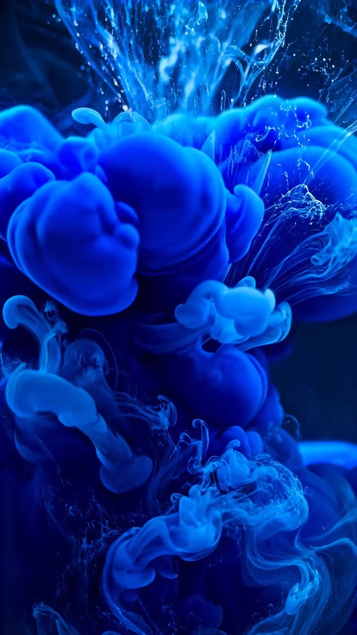 Esplosione di inchiostro blu vibrante sott'acqua, fluido astratto cinematografico che forma pennacchi simili a nuvole e vortica
