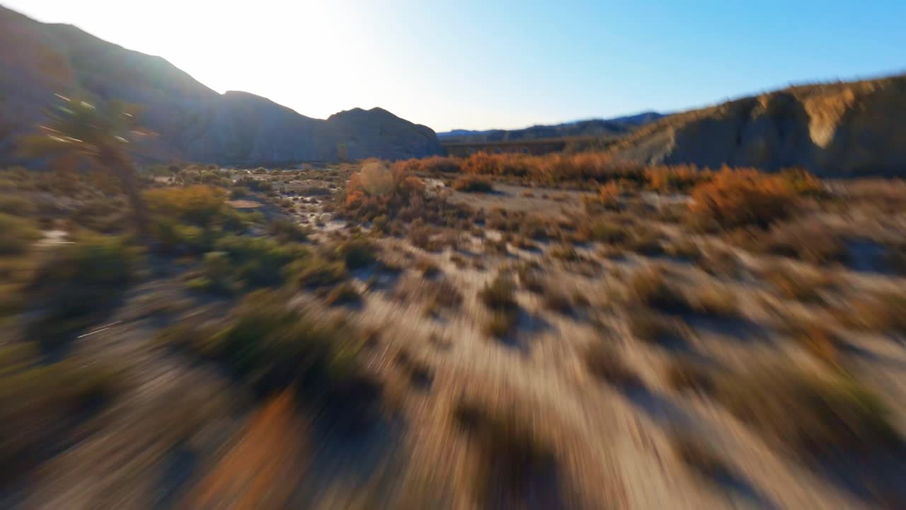 vista aérea de drones fpv volando sobre un paisaje accidentado y desértico al amanecer