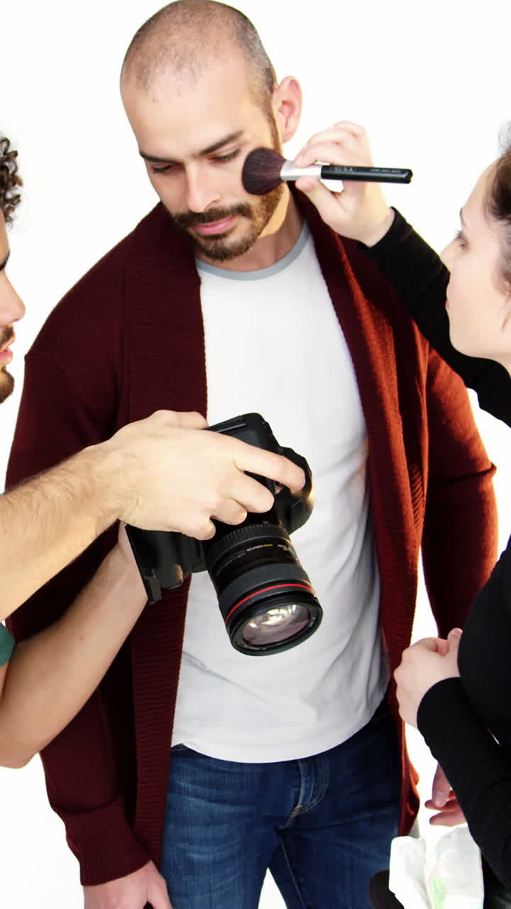 Modelo maquillándose el rostro con el fotógrafo