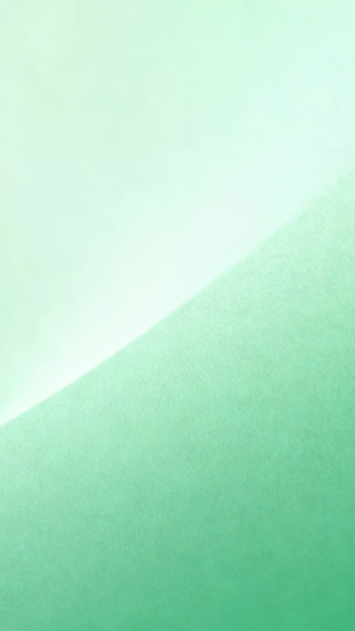 Vídeo vertical: Câmera gravando superfície verde-menta na parede, mostrando gradiente diagonal.