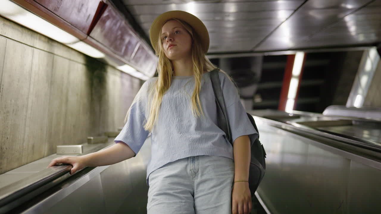 Jovem mulher em escada rolante subterrânea, conceito de mobilidade urbana e estilo de vida de viajante