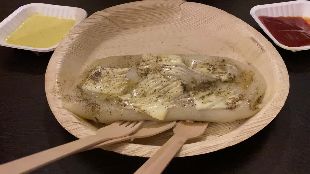 벵골 요리 치킨 치즈 파티샤파타의 전통적이고 절묘한 디저트는 재활용 종이 접시와 나무 수저에 노란색 두부와 붉은 소스를 곁들였습니다.