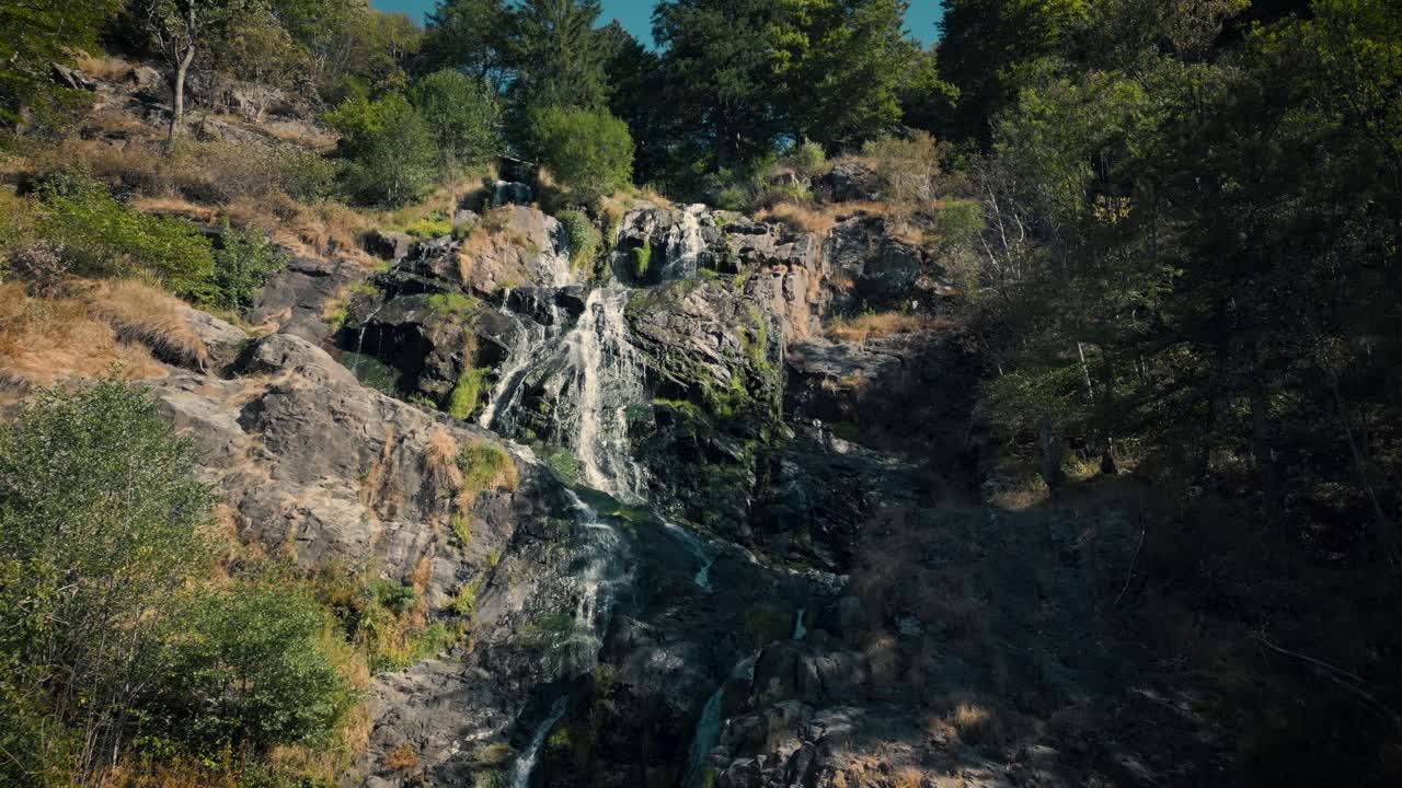 lento vuelo aéreo hacia atrás desde la cascada de todtnau en un día soleado, alemania