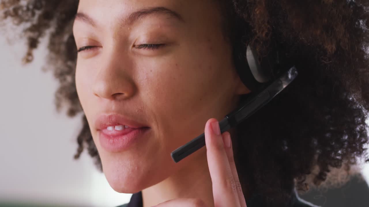 Mixed race woman wearing headset with mix in creative office