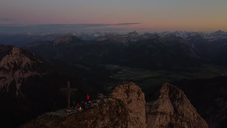 drone flying above a summit in the alps at sunset