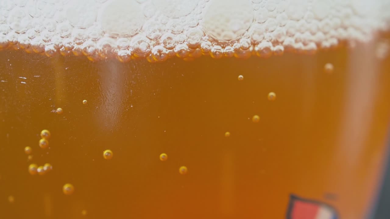 bebida carbonatada de color ámbar con burbujas que se elevan a la superficie