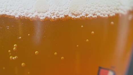 amber colored carbonated beverage with bubbles rising to the surface