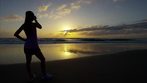 mujer asiática americana usando reloj deportivo por el mar