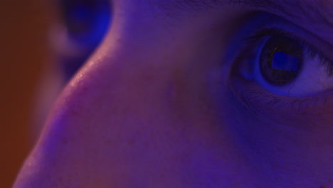 close-up of a man's eyes reflecting the paramount+ logo in a dimly lit room at night