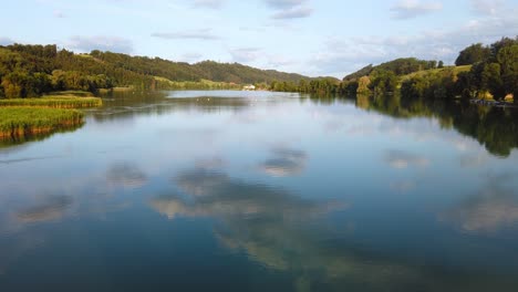 lake in switzerland, pan upwards from lake to sky, reflected clouds