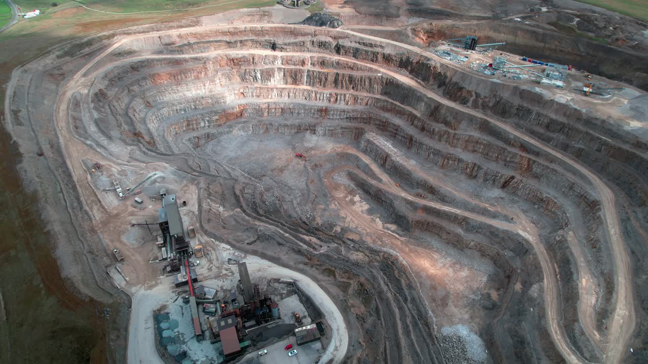 Yorkshire aggregate mining quarry aerial view tilting upwards to countryside scenery