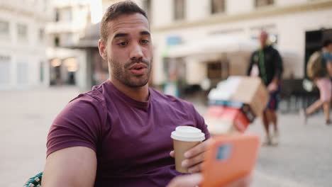 young man having a video call sitting in a cafe.