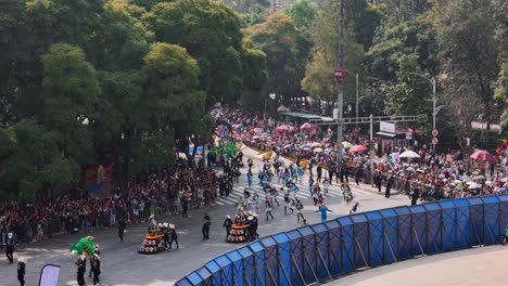 aerial shot of a group of people and parade floats participating in the traditional day of the dead parade held on paseo de la reforma in mexico city