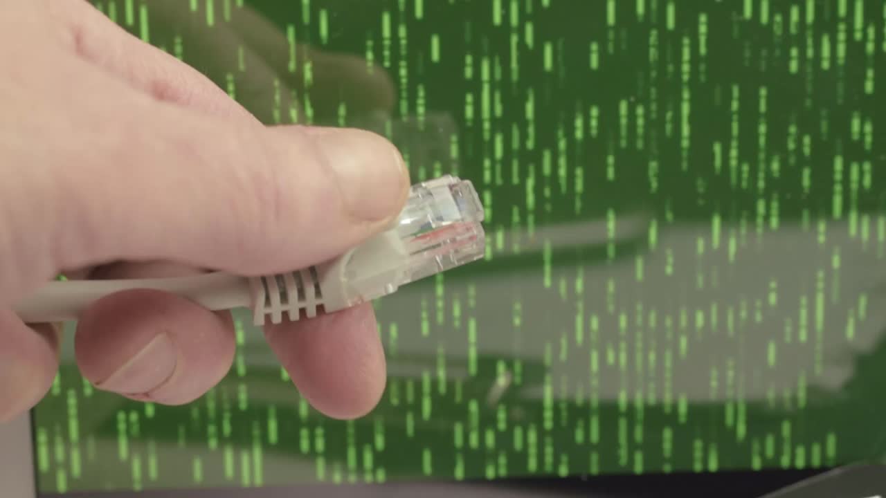 Network engineer holding Ethernet cables with green binary data output background