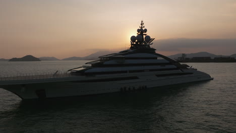 private super yacht anchored in hong kong at sunset luxury boat, ci=inematic circling drone shot