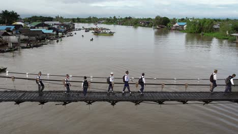 aerial martapura río actividad diaria gente caminando a través del puente, punto de referencia de banjarmasin con barco río por la mañana