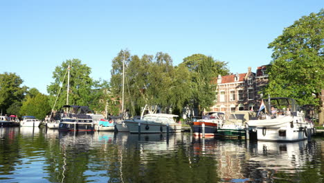 una vista de los barcos de muelle a lo largo de la orilla del río kattensingel en gouda, holanda del sur, países bajos