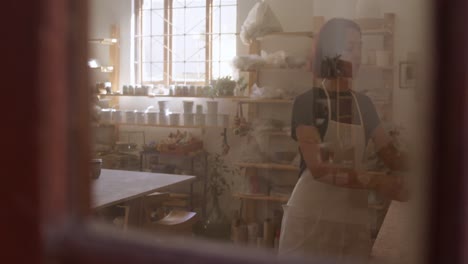 Young-female-potter-working-in-her-studio