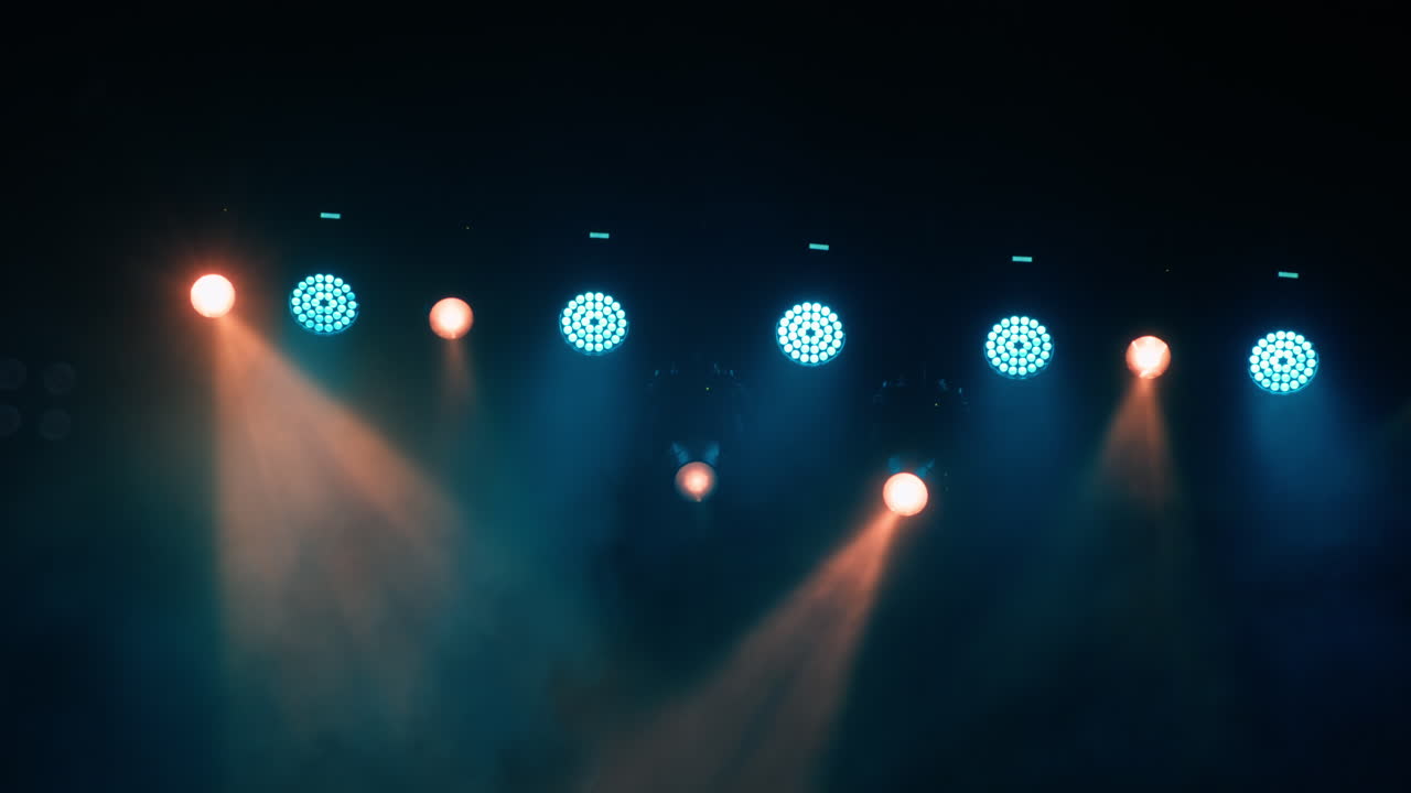 Dynamic Stage Lights Flashing Blue and Orange Through Smoke