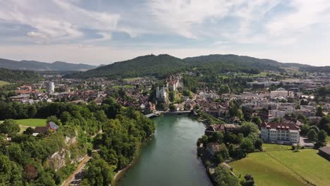 the city of aarburg with the aare river flowing through it from an aerial perspective. a historic city in the bezirk zofingen district on a sunny day