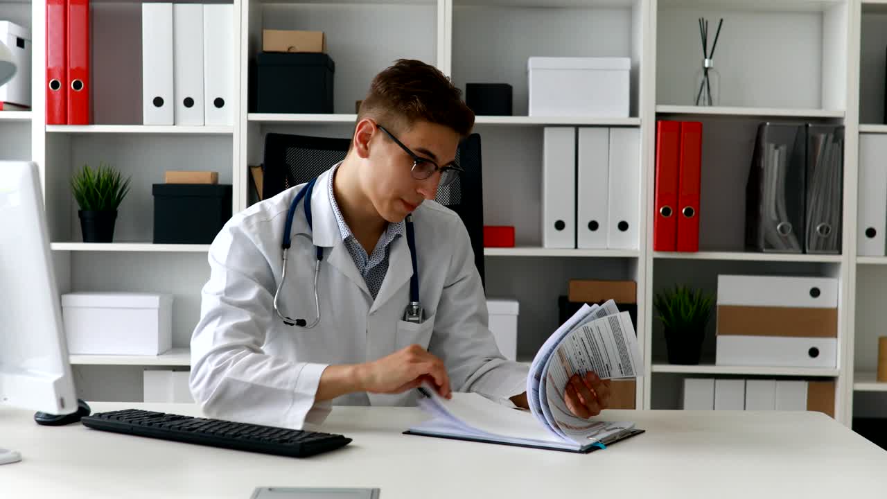 Jovem médico olhando documentos no local de trabalho