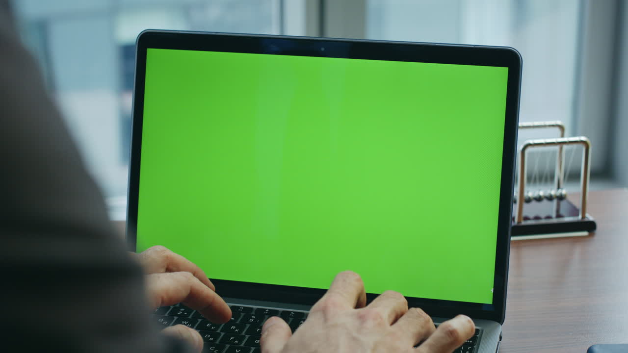 manos escribiendo en pantalla verde computadora escribiendo texto en el teclado en el lugar de trabajo de cerca